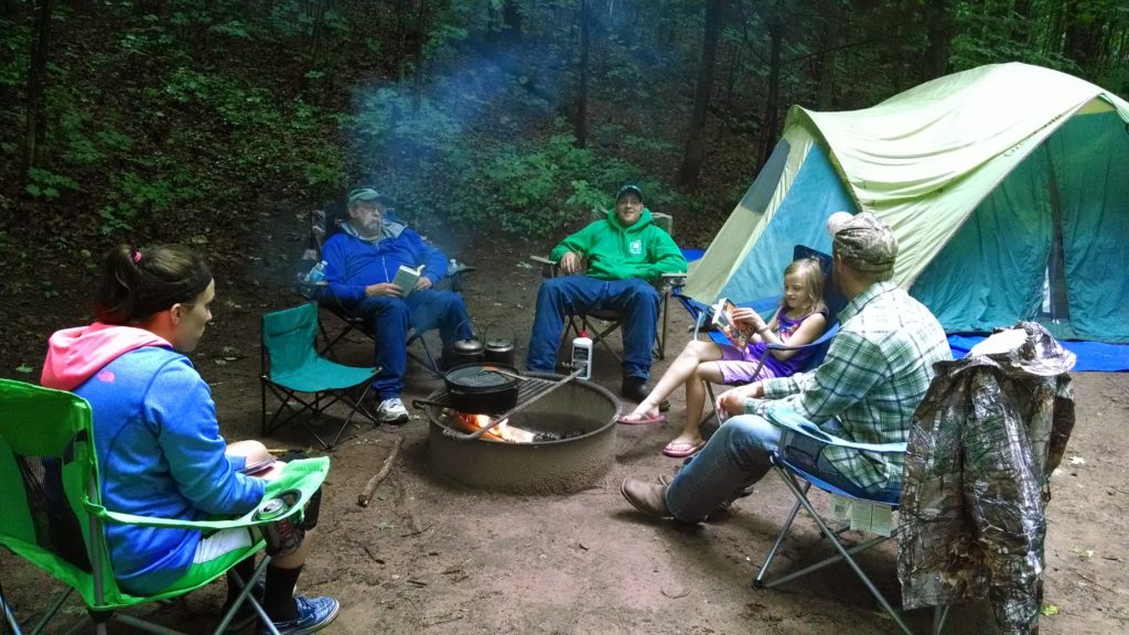 image of family sitting around campfire